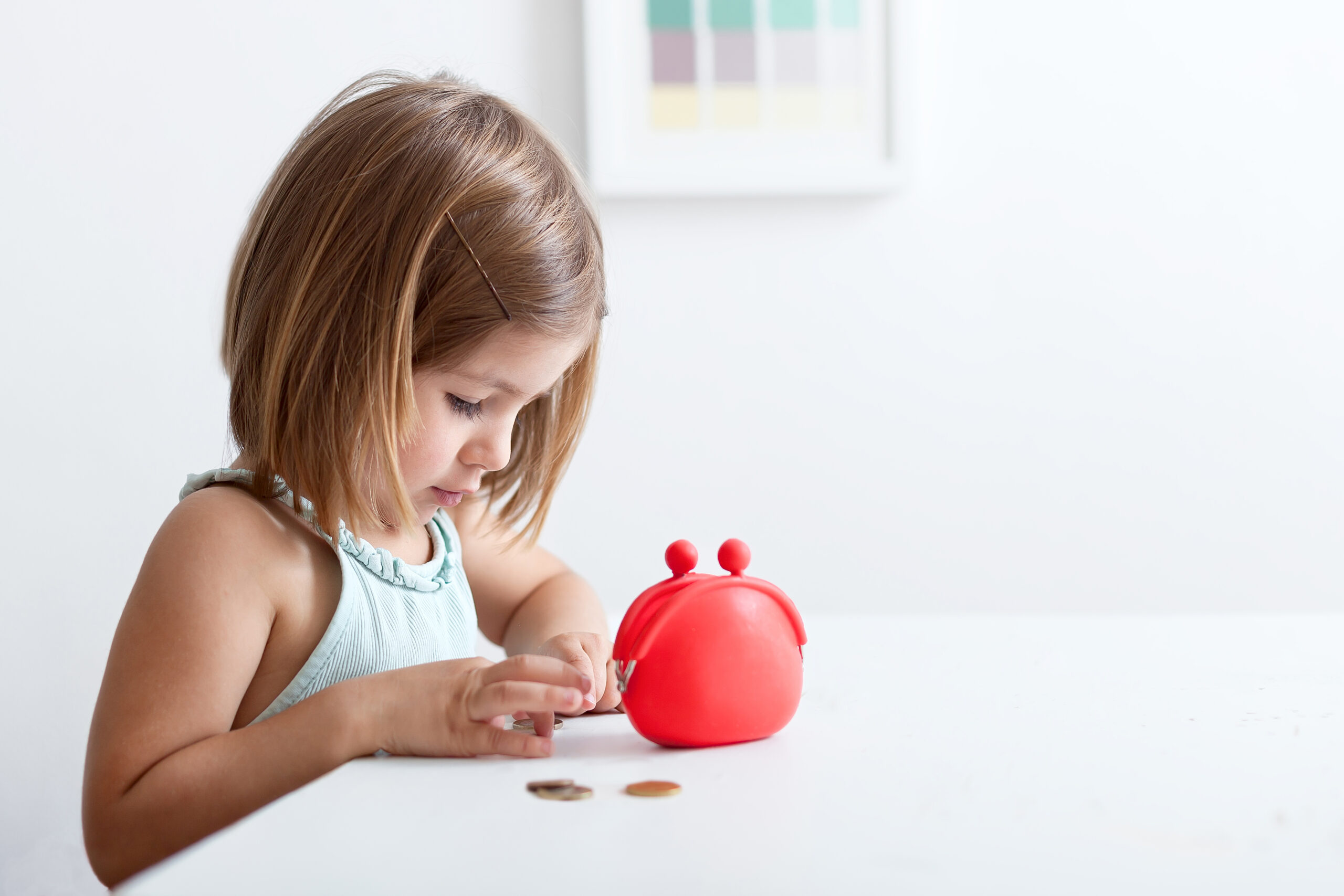 Mała dziewczynka przy stole liczy pieniądze